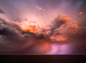 After the Sunset — an offshore storm glowing with sunset colour and lightning over the ocean