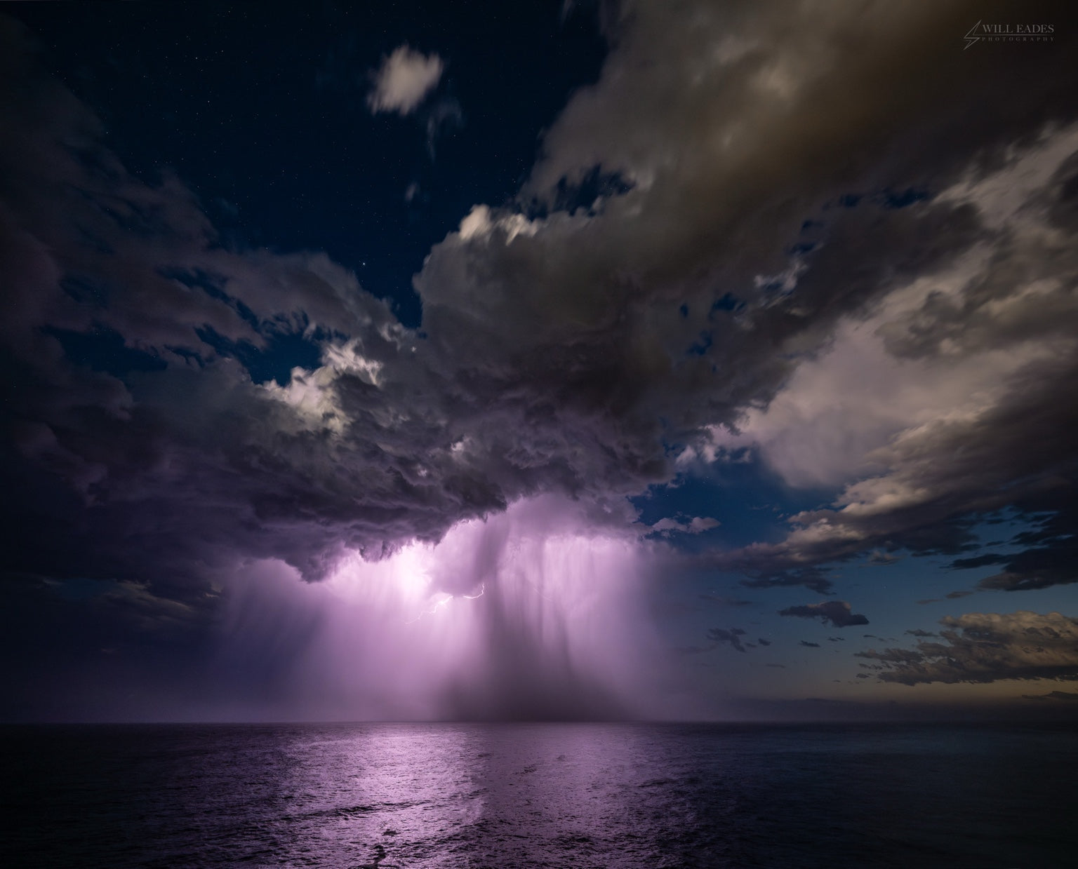 Coastal Storm — lightning illuminating a coastal thunderstorm and rain core over the ocean at night