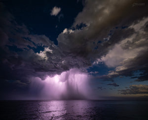 Coastal Storm — lightning illuminating a coastal thunderstorm and rain core over the ocean at night