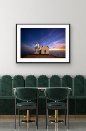 Last Light framed above deep green banquette seating in a refined dining space