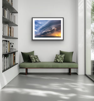 Sunset Storm framed above a green bench in a modern interior